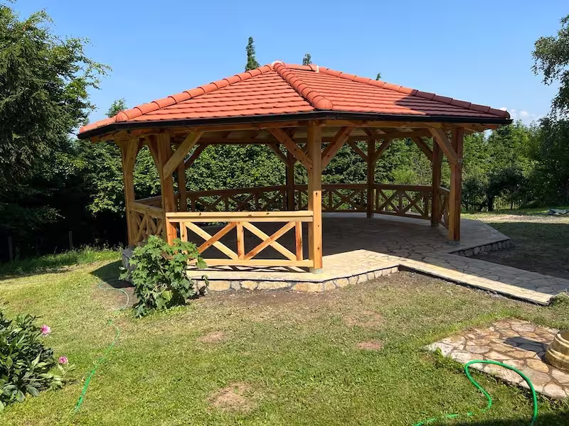 Drveni letnjikovac za odmor u dvorištu sa betonskom stazom